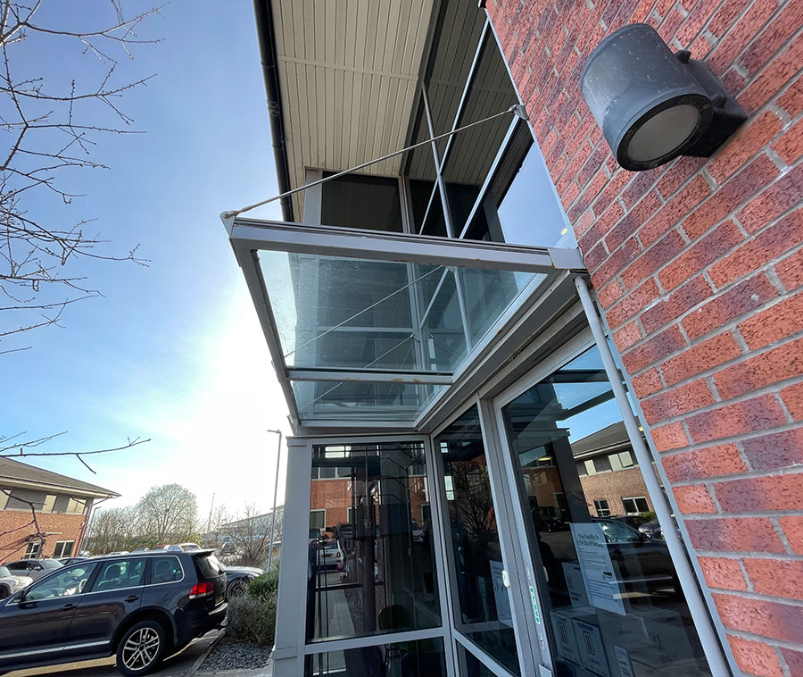 Glass front door to a brick building.